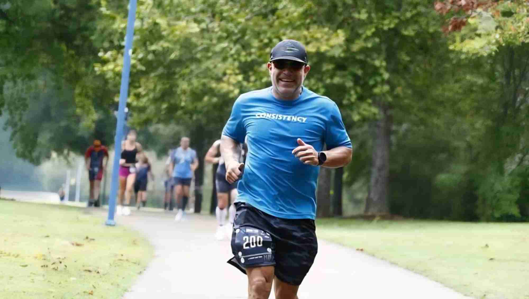 A man smiling and going on a run.