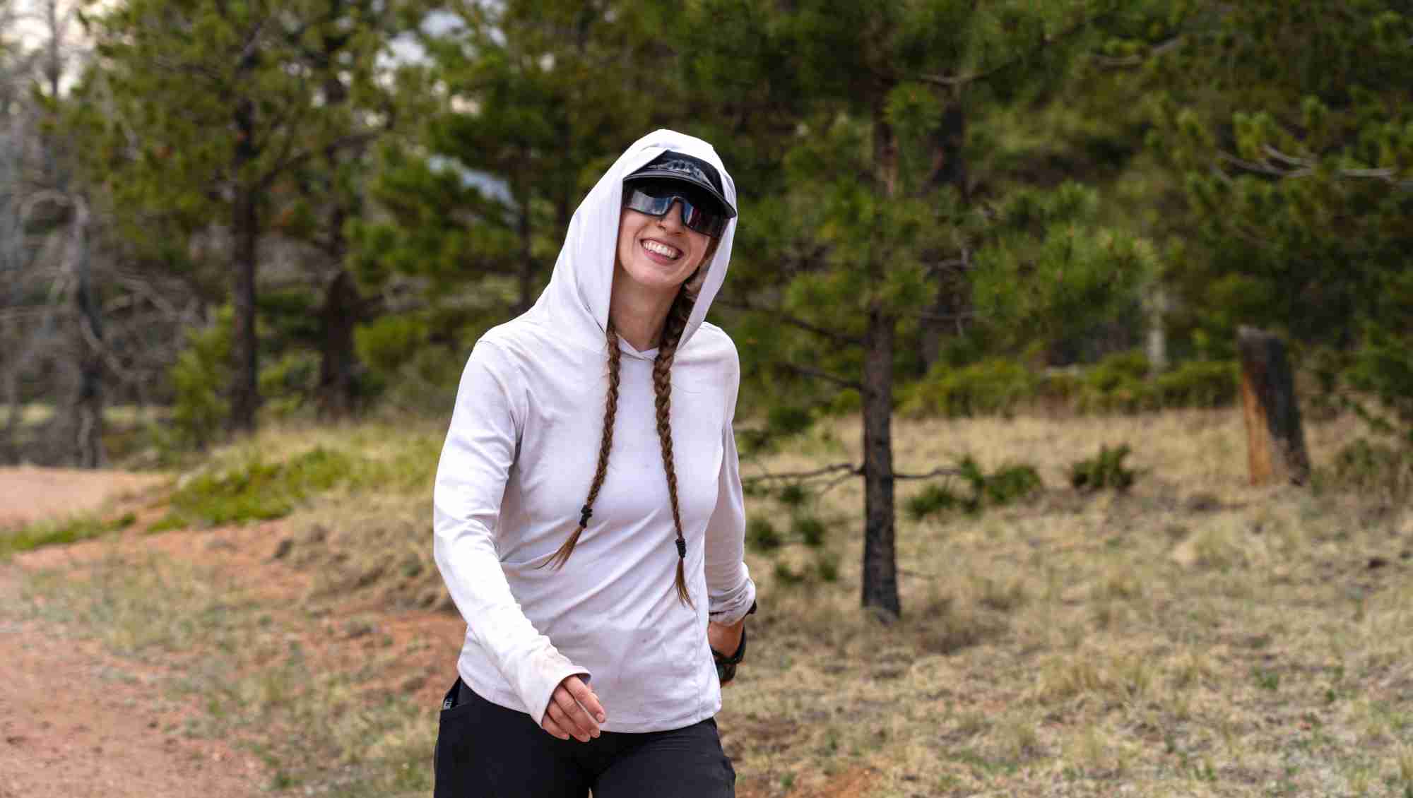 Woman walking in the mountains smiling.