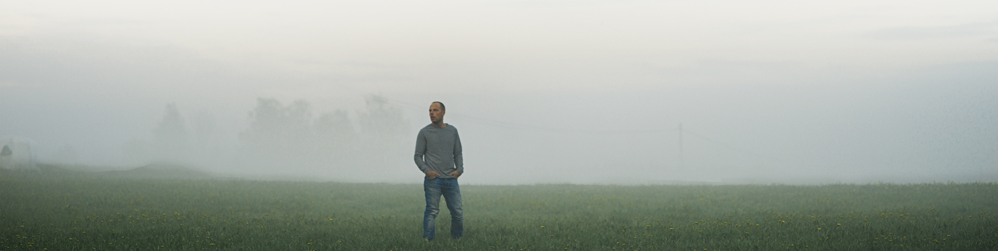 a man stands in a foggy field