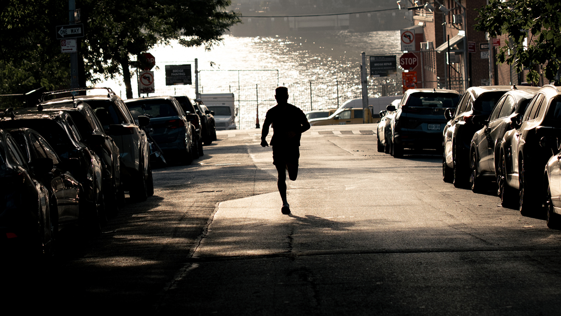 silhouette of man running down a hill
