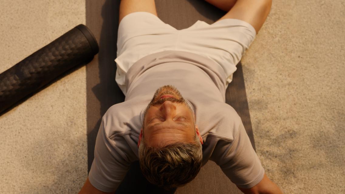 Man laying down on mat.