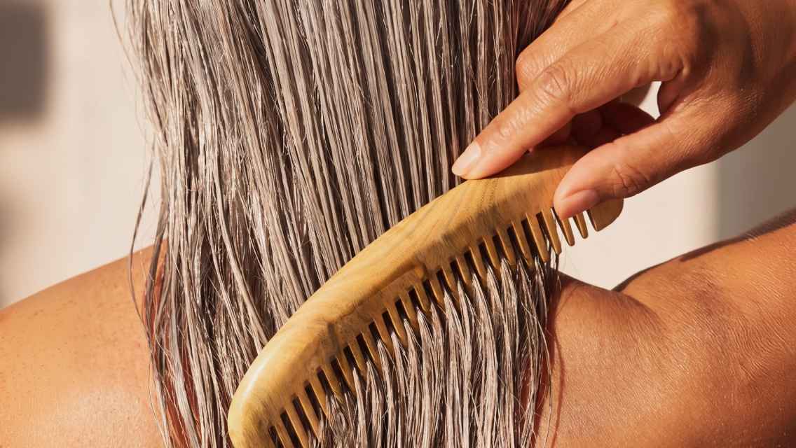 Comb combing through wet hair.