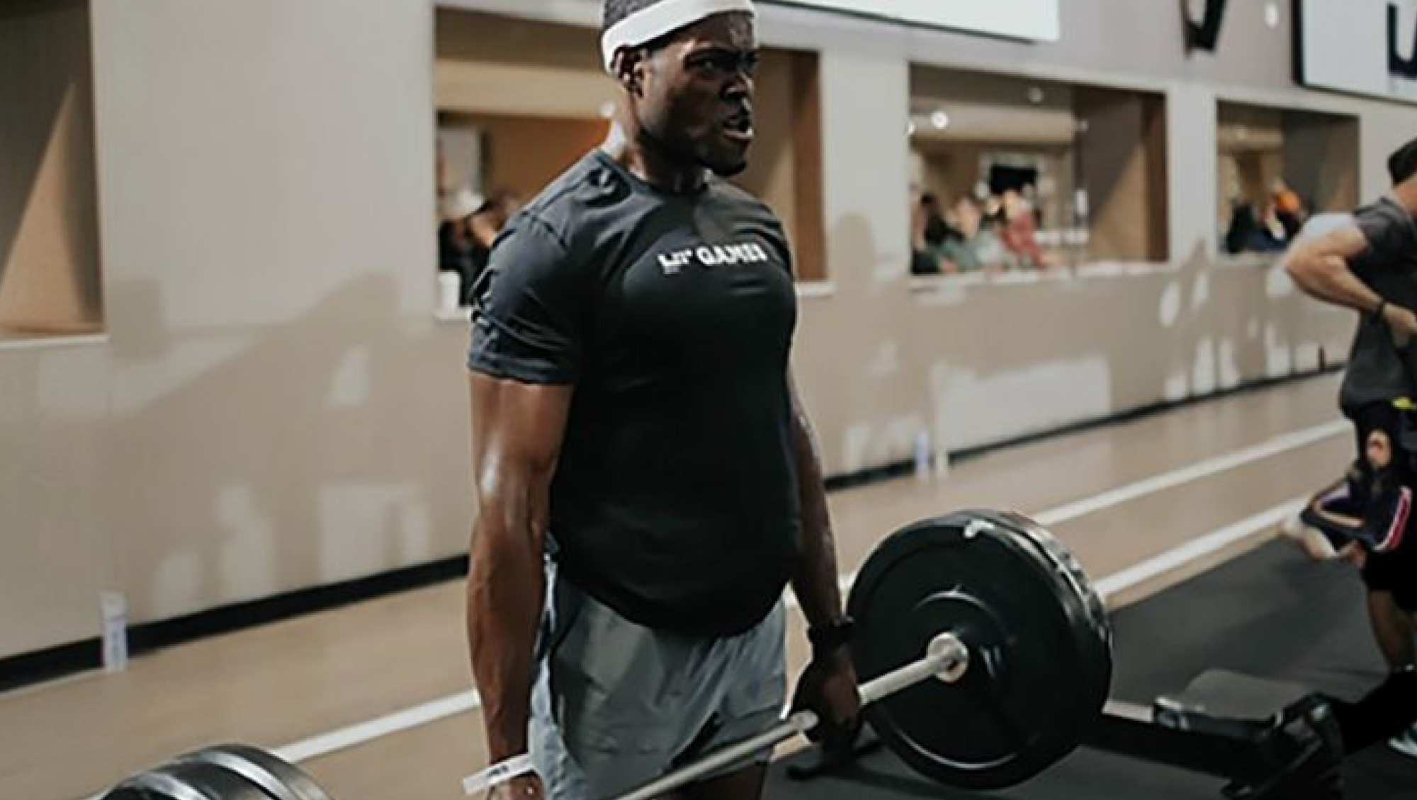 Member lifting a barbell with weights.
