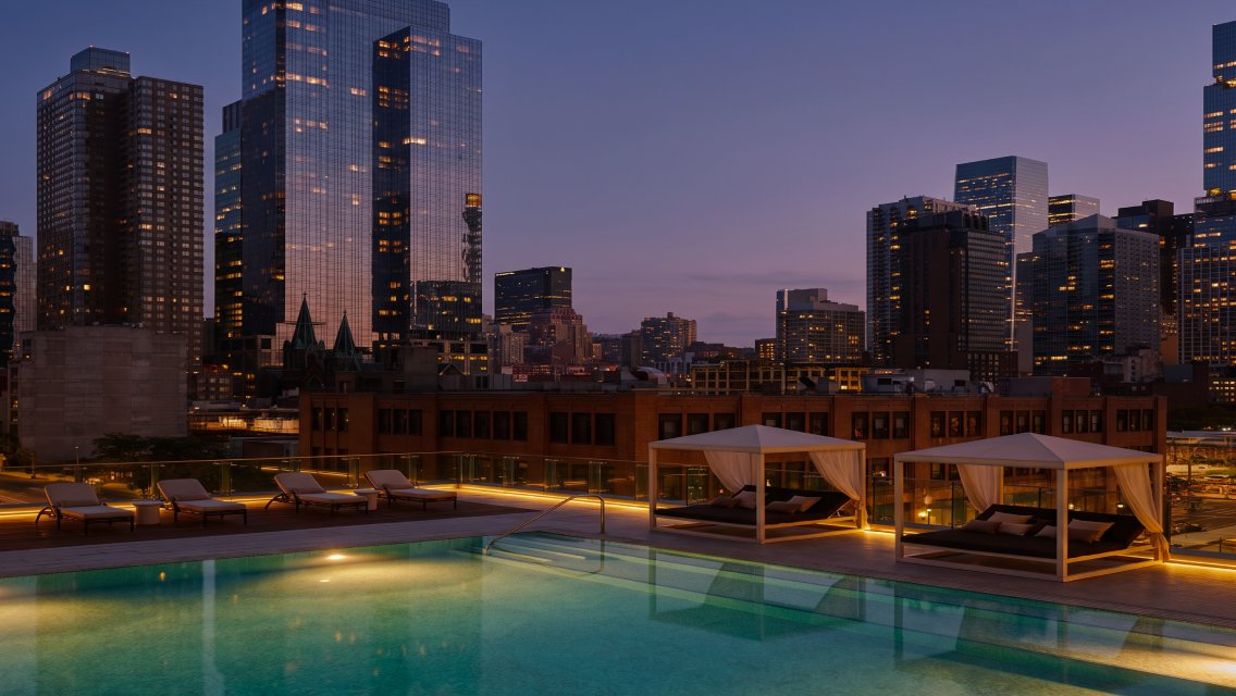 The rooftop of Life Time Sky featuring a pool and view of city buildings.