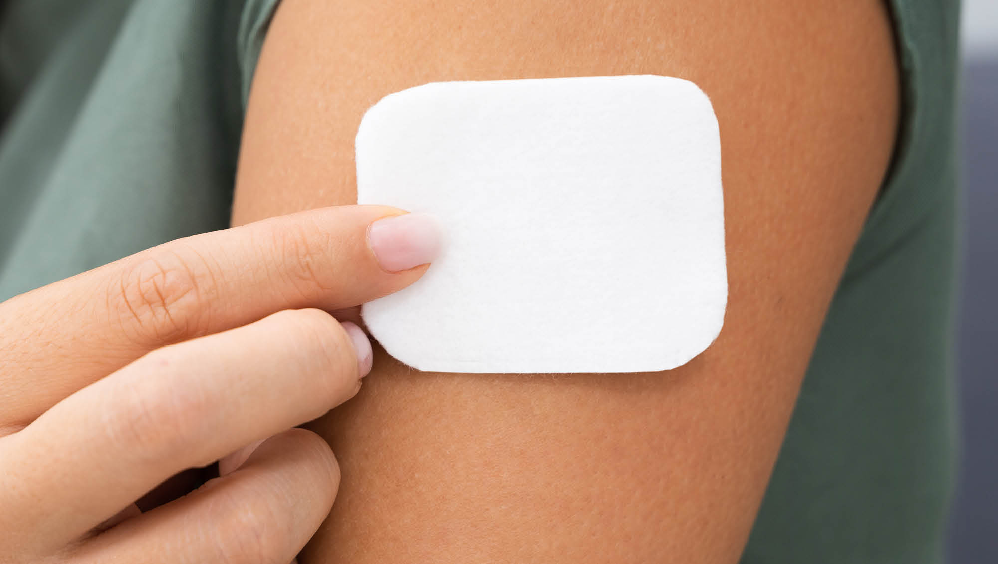 a woman puts a patch on her arm