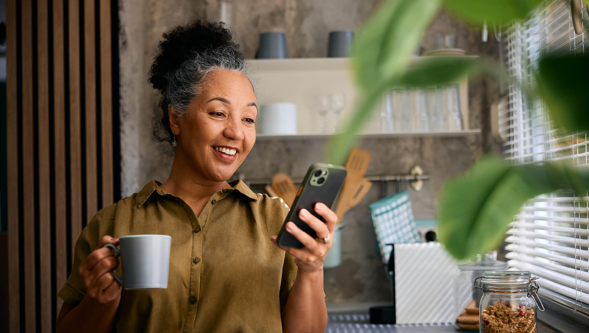 a woman drinks her coffee while looking at her phone