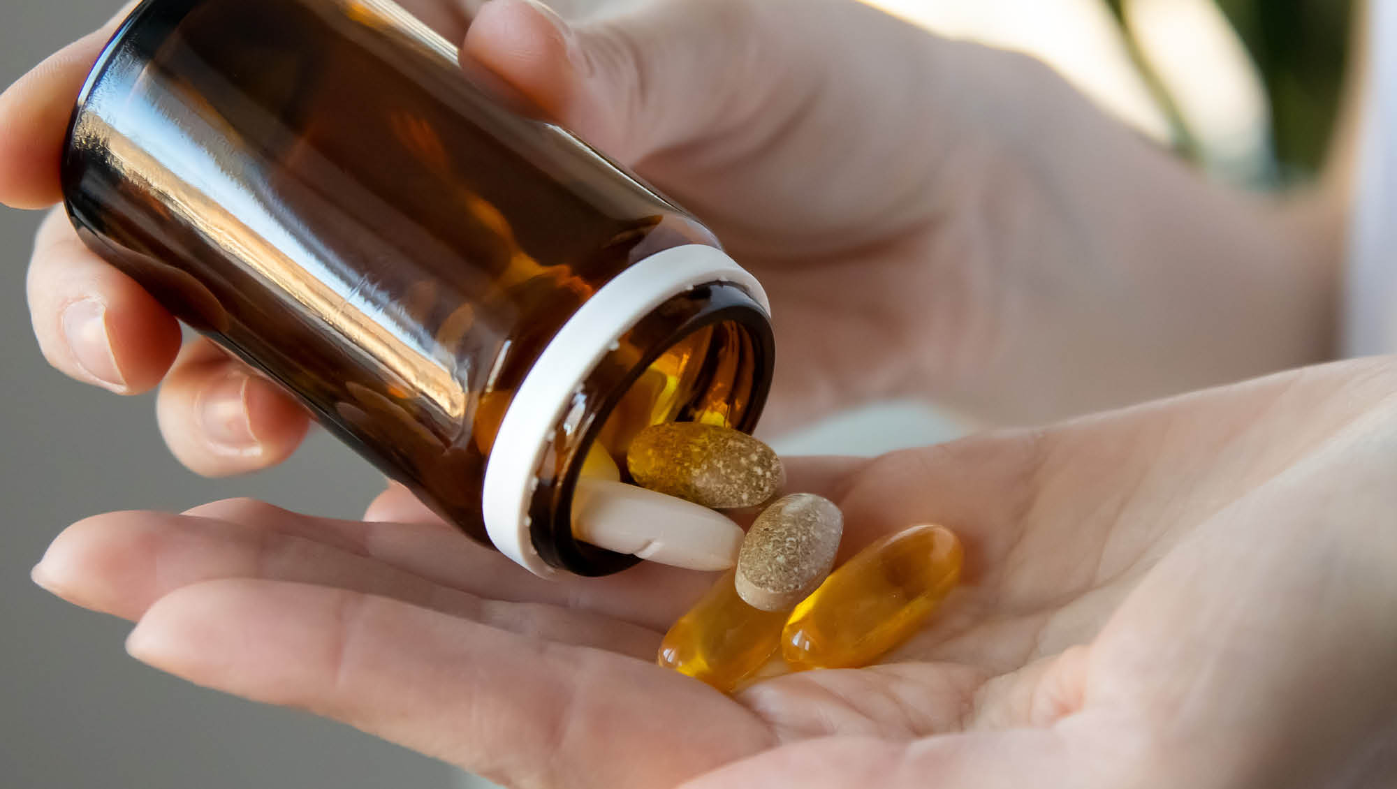 person pouring supplements into their hand