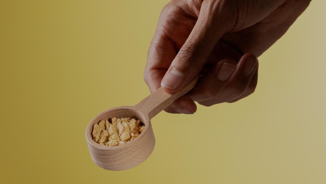 Hand scooping protein powder.