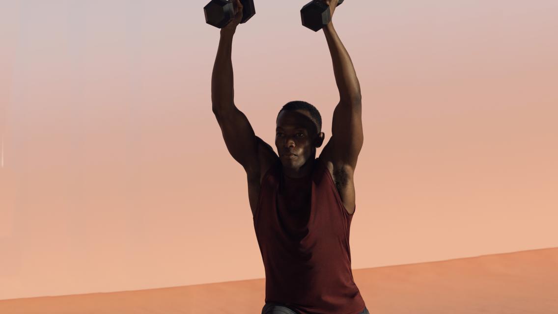 Man holding weights above his head.
