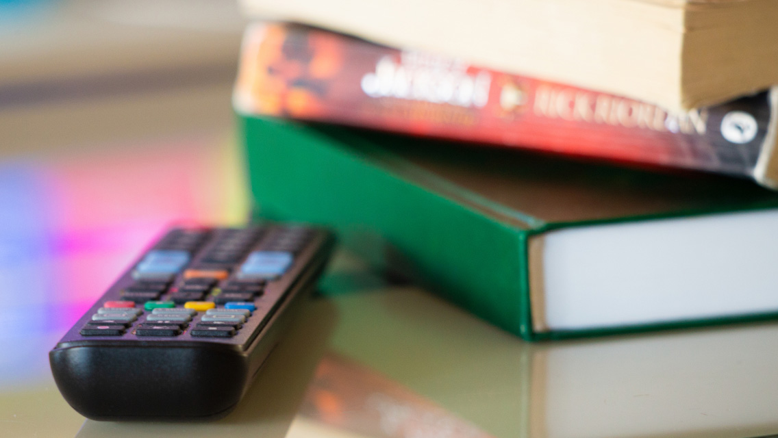 a remote control and stack of books