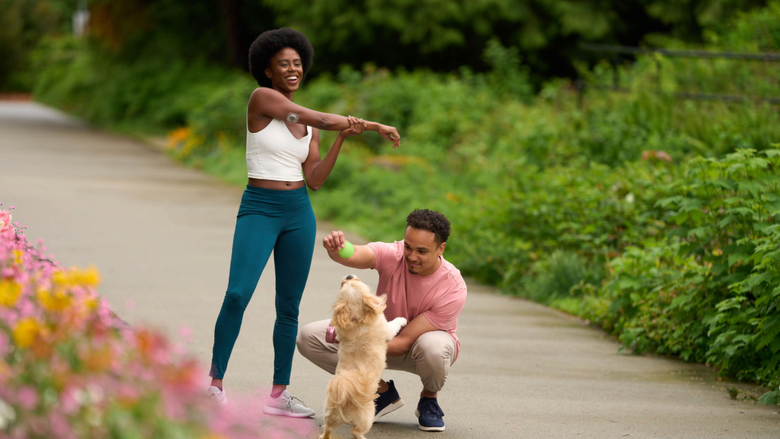 a man and a woman walk with their dog