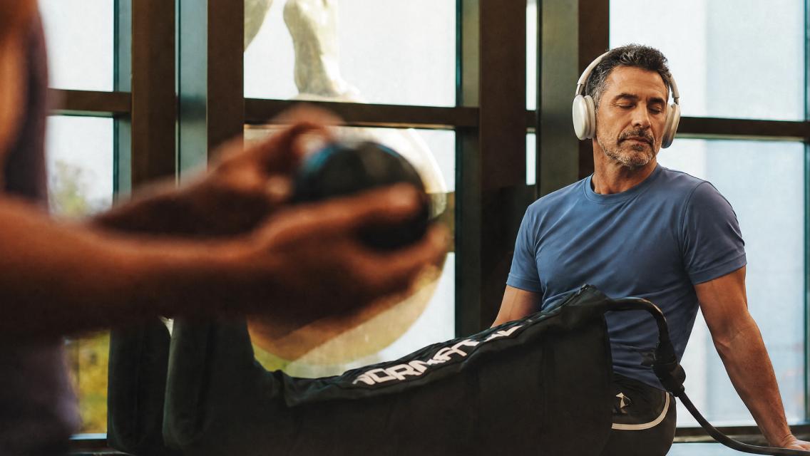 Man with normatec sleeves on.