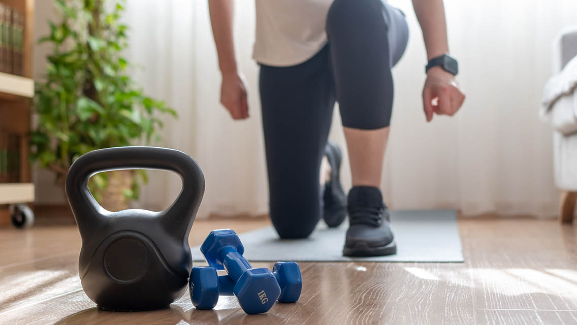 a person in a lunge with a kettlebell and hand weights in front of them