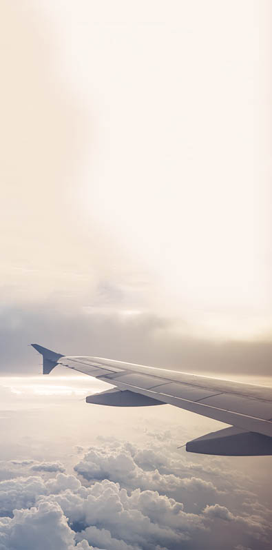 Cropped image of an airplane  only showing the wing while in flight above the clouds 
