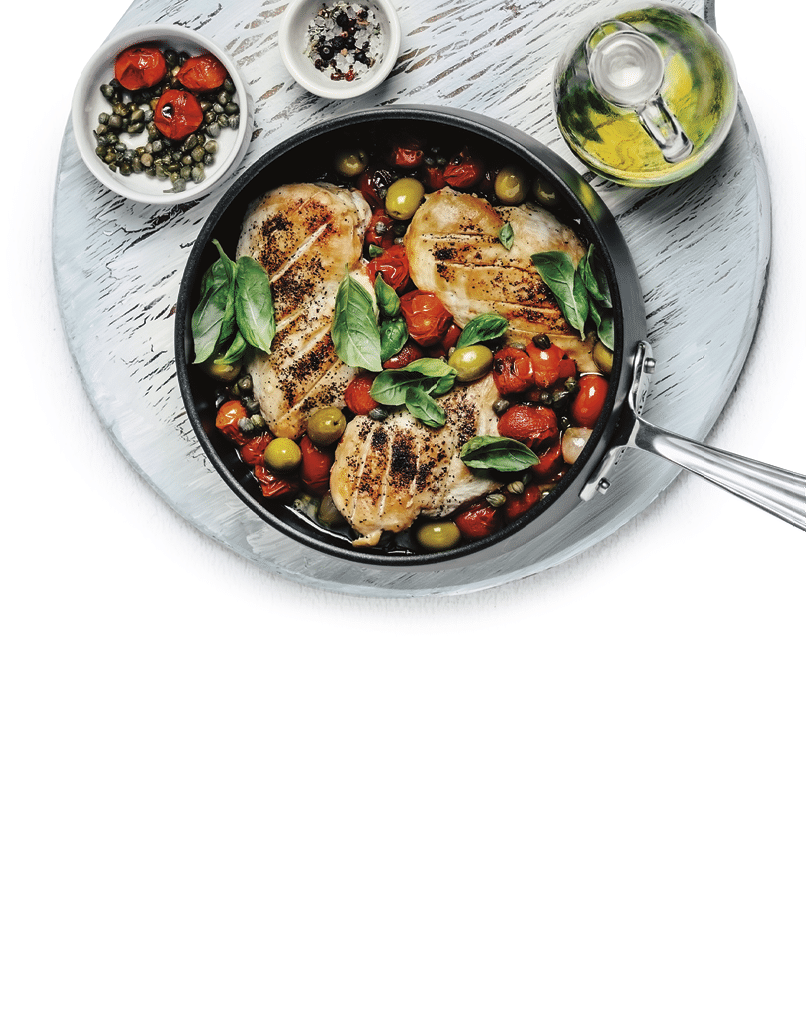 A cooking pan with chicken stew on wooden cutting board on white background