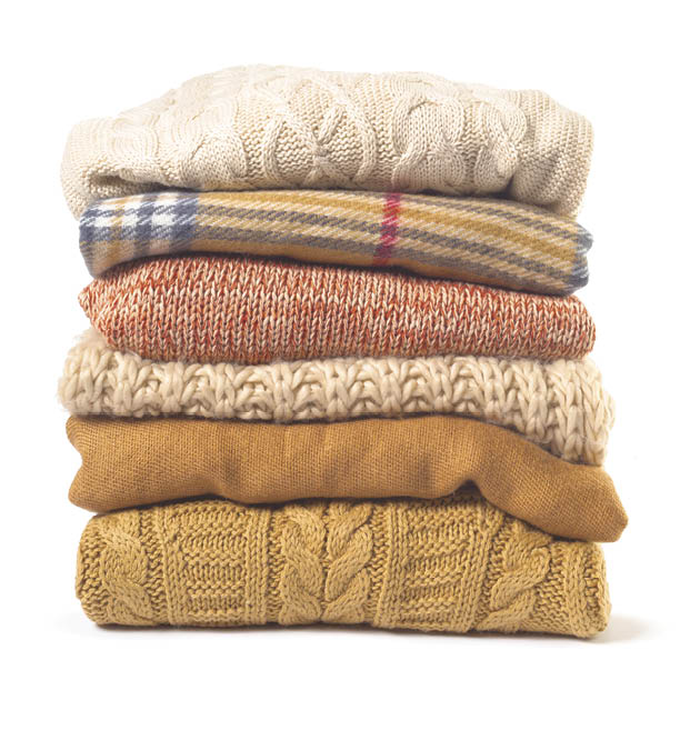 Stack of various sweaters isolated on white background