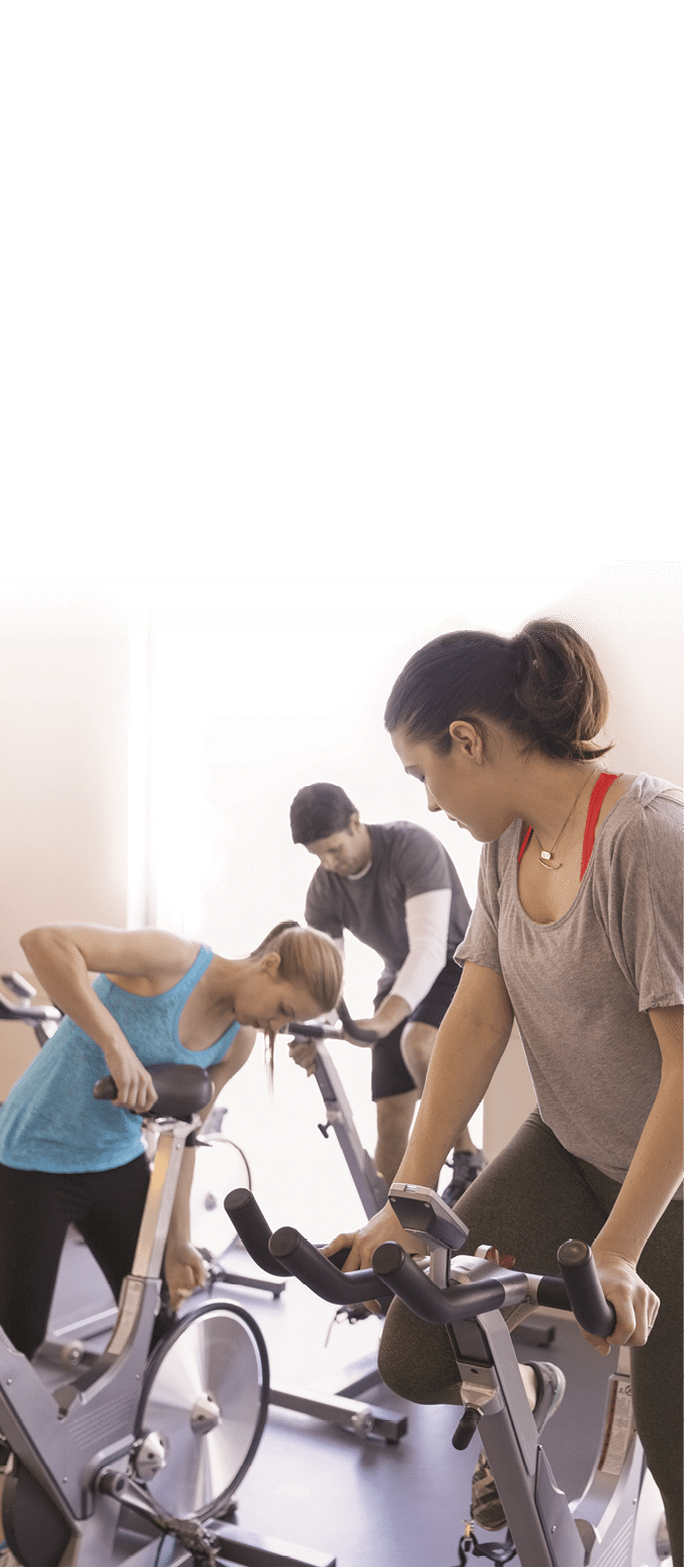 Woman adjusting seat stationary bike in spin class