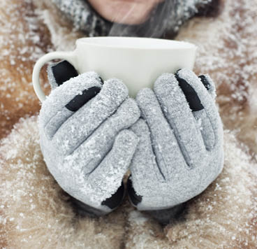 Woman holding a mug to get warm in winter
