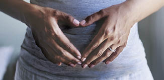 Cropped shot of a pregnant woman touching her belly
