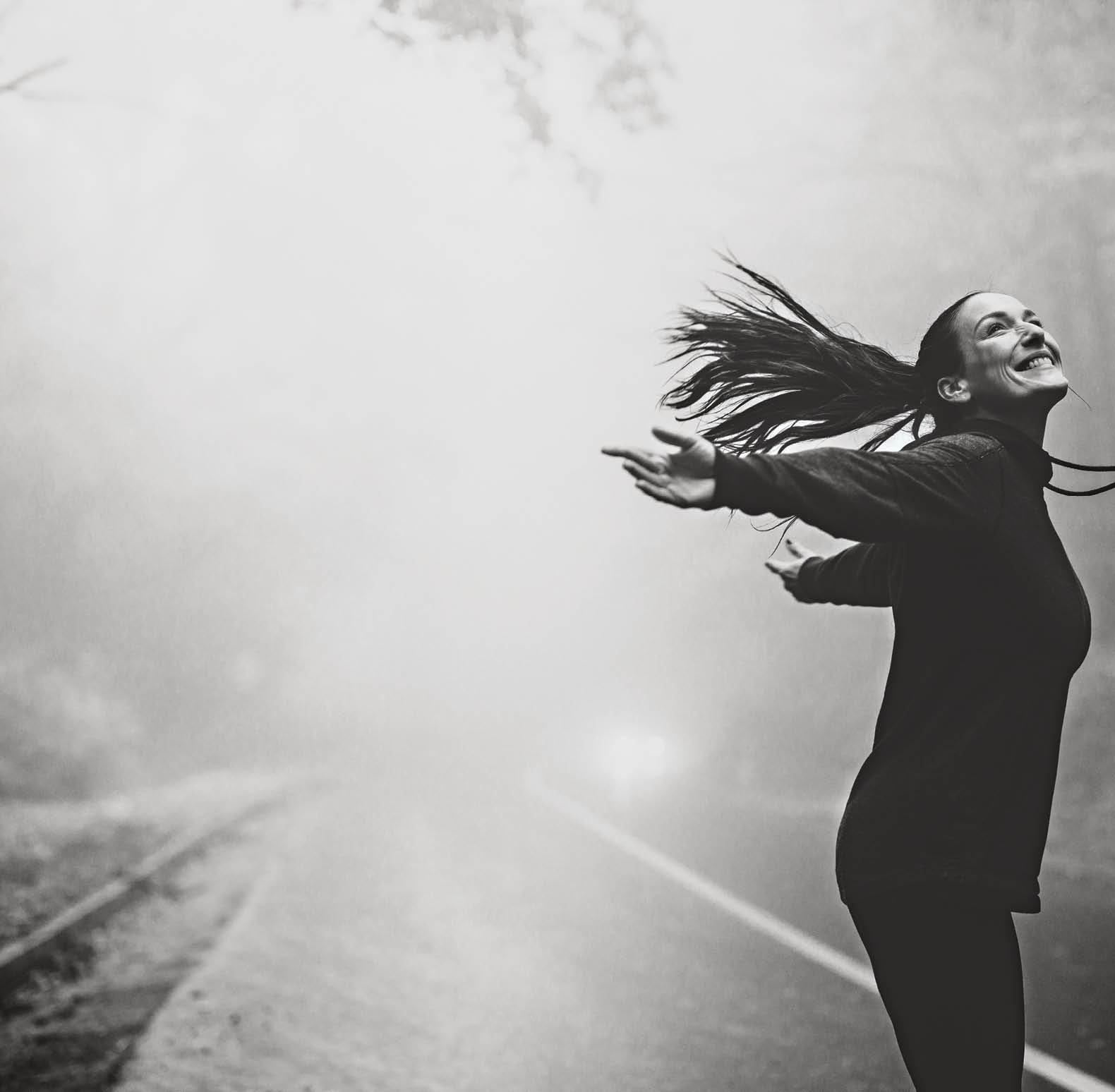 Yong happy woman enjoying in rain during misty day in nature  Copy space 