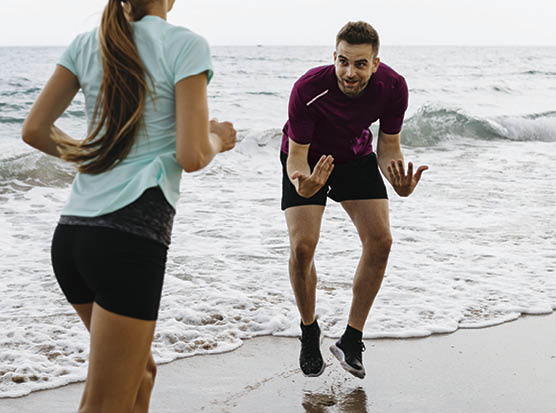 Female jogger on the beach with her coach