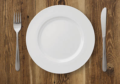 Table setting on rustic wood background - plate  fork and knife