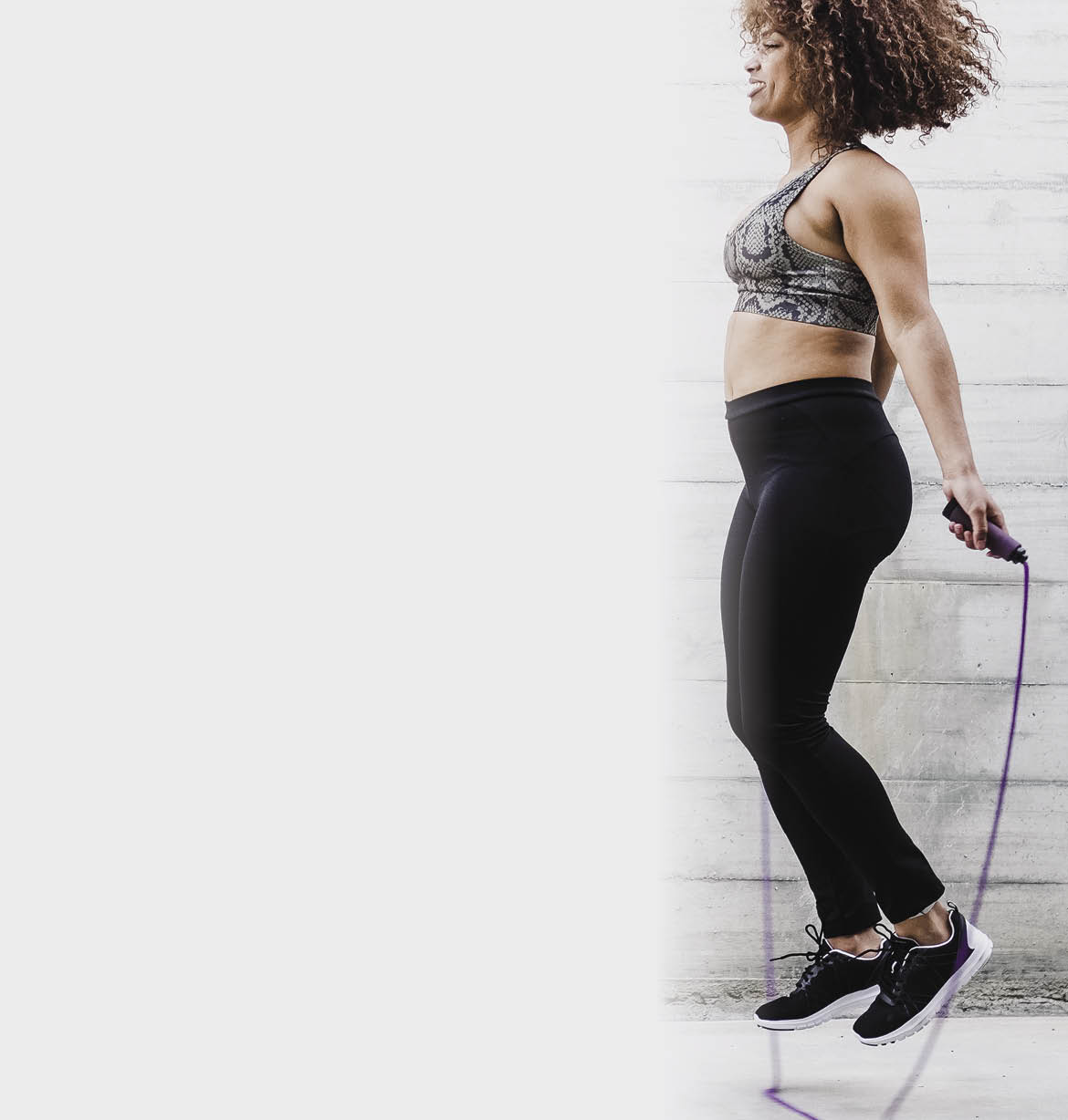 Curvy African American Woman Skipping Rope In Urban Area