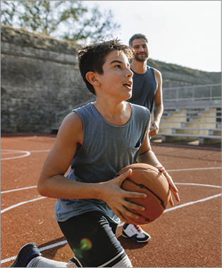 Photo of young basketball player practicing is basketball with his coach