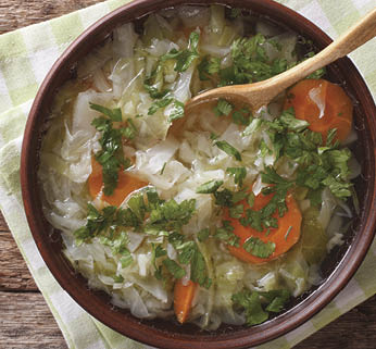 Hot vegetable soup with cabbage close up in a bowl on the table  horizontal view from above