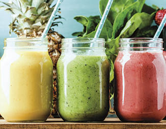 Freshly blended fruit smoothies of various colors and tastes  in glass jars  Yellow, red, green  Turquoise blue background