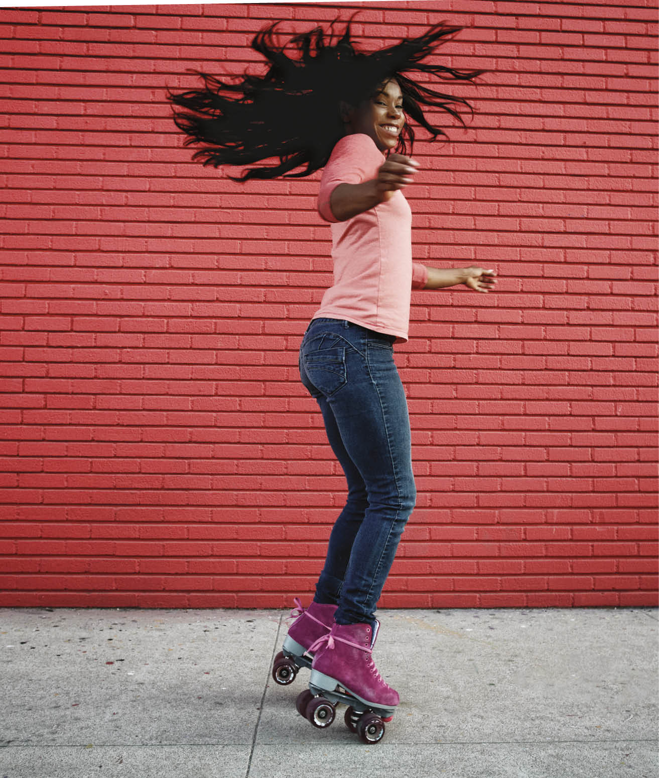 Black woman dancing on roller skates on sidewalk