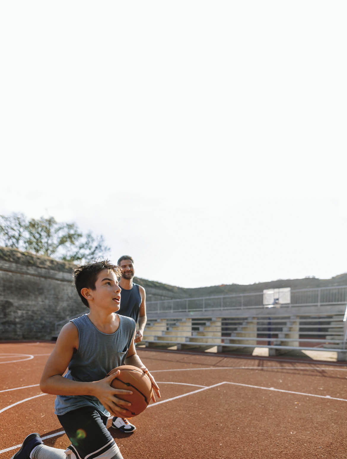 Photo of young basketball player practicing is basketball with his coach