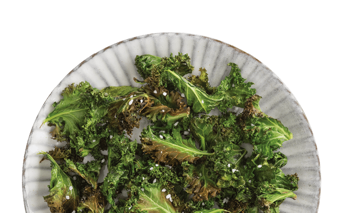 Kale chips with sea salt on a white plate