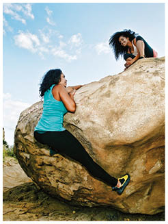 Women climbing on boulder