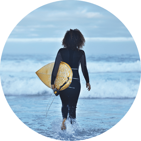 Group of surfers getting ready to go in the water at sunrise