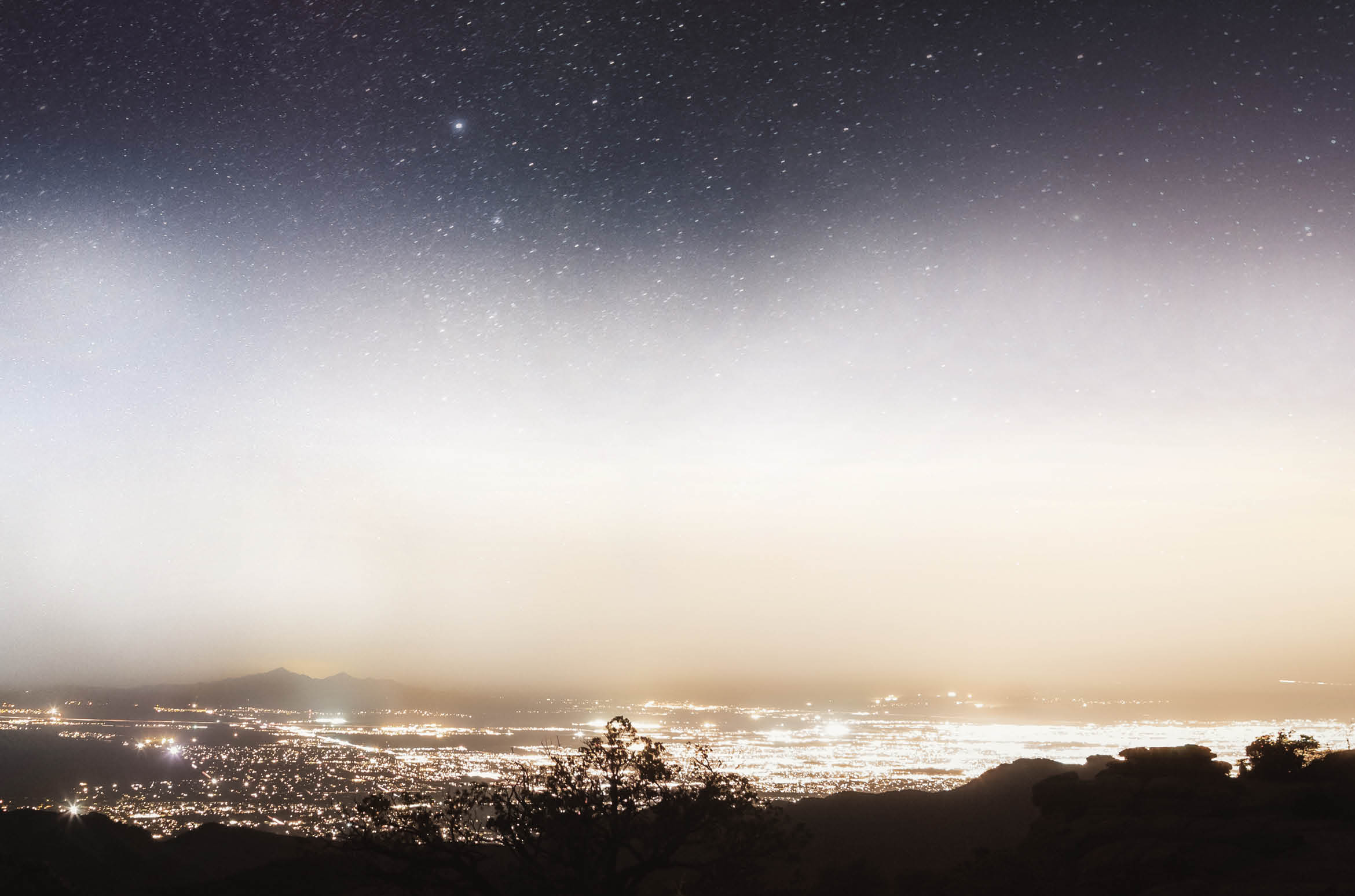 The Milky way rises over the bright lights of Tucson, Arizona 