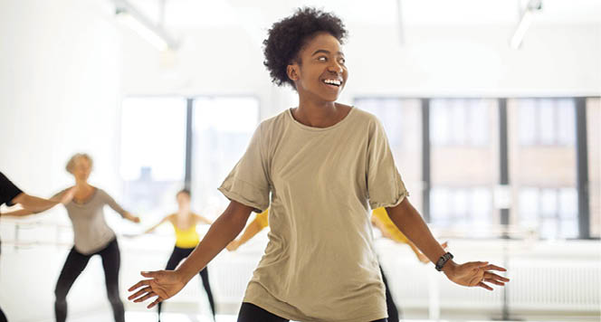 Young african woman practicing fitness dance moves at health club  Females doing a fitness dance in a class 