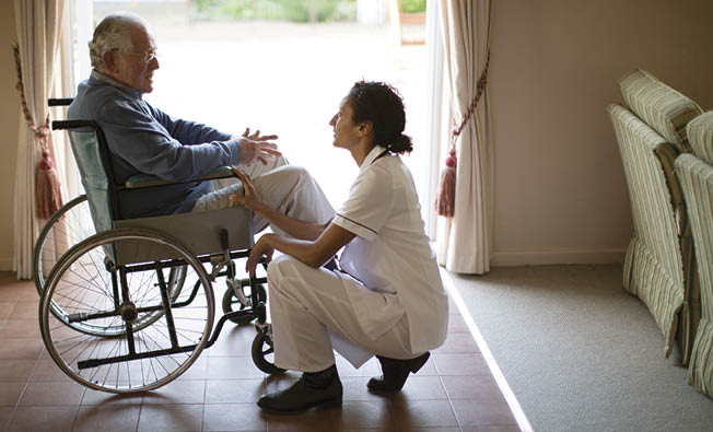 Nurse talking to patient in wheelchair
