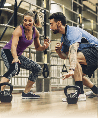 Four people working out using kettlebells on a wooden fitness floor 