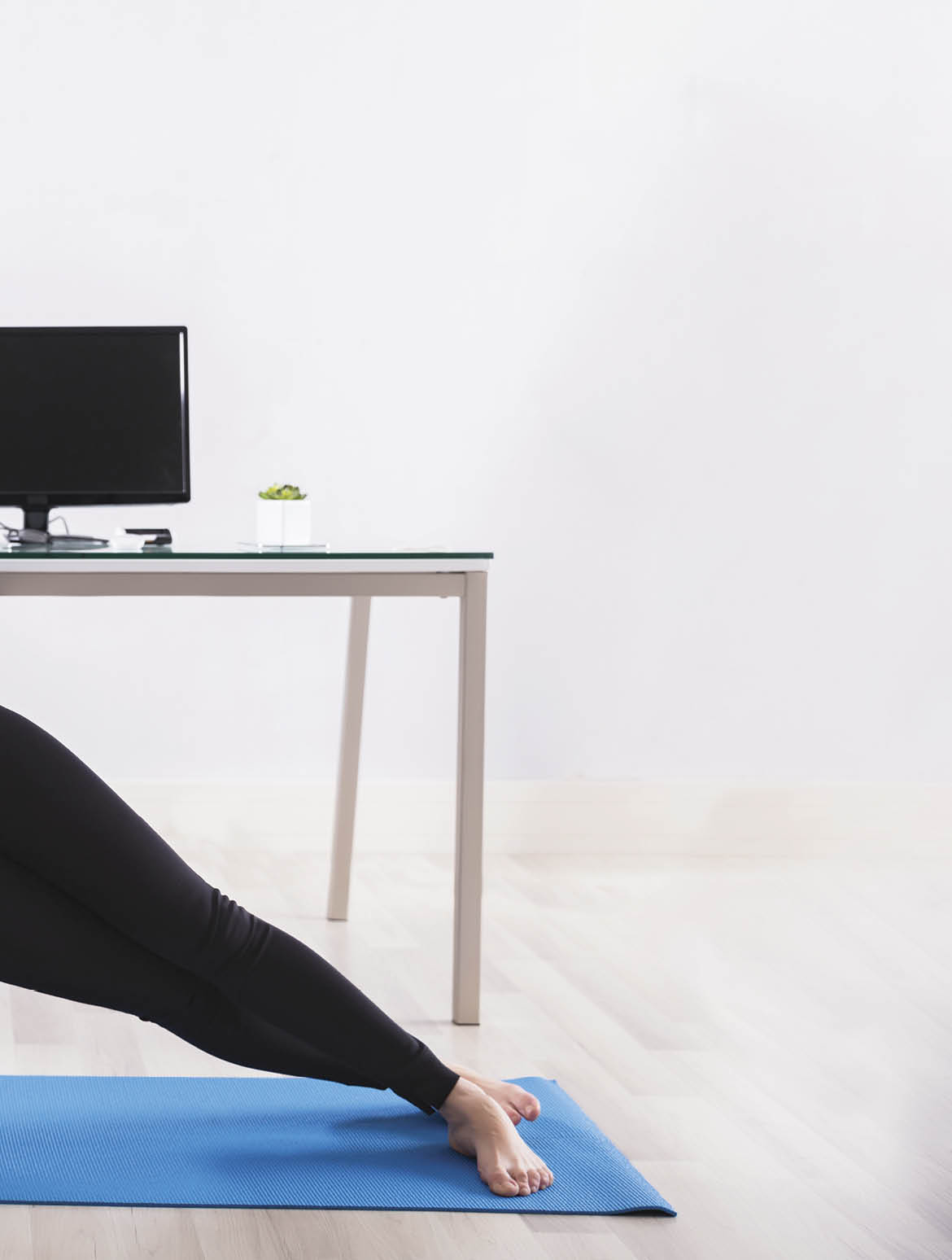 Young Businesswoman Doing Stretching Exercise On Exercise Mat At Workplace
