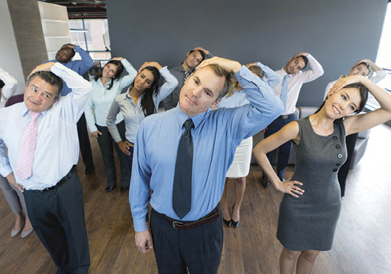Group of people in an active break at the office stretching their neck and relaxing