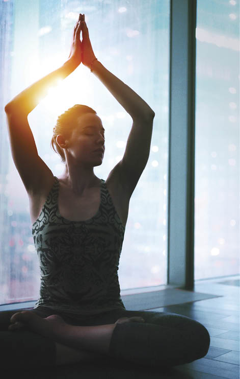 Adult caucasian woman practicing yoga exercise at home    skyscraper window 