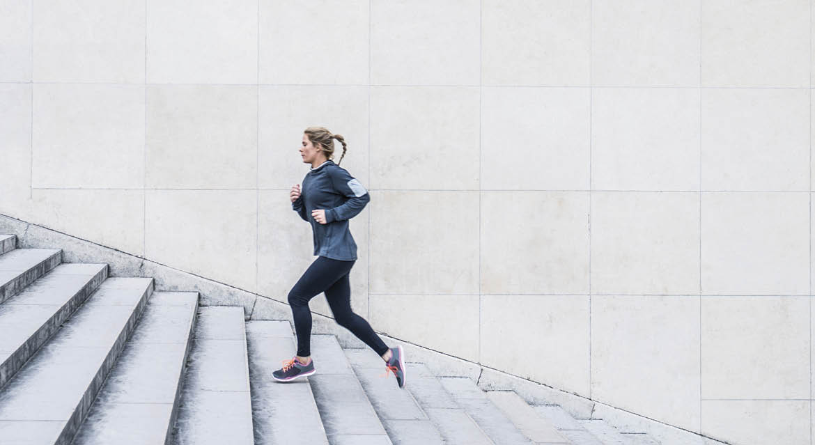 Caucasian woman running up staircase