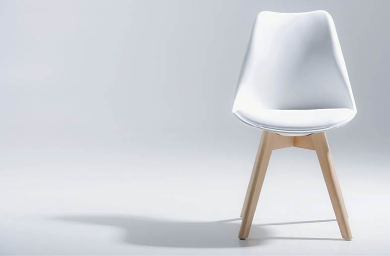 Studio shot of stylish chair with white top and light wooden legs standing on white