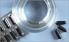 Activated charcoal capsules and glass of water on a blue background  top view
