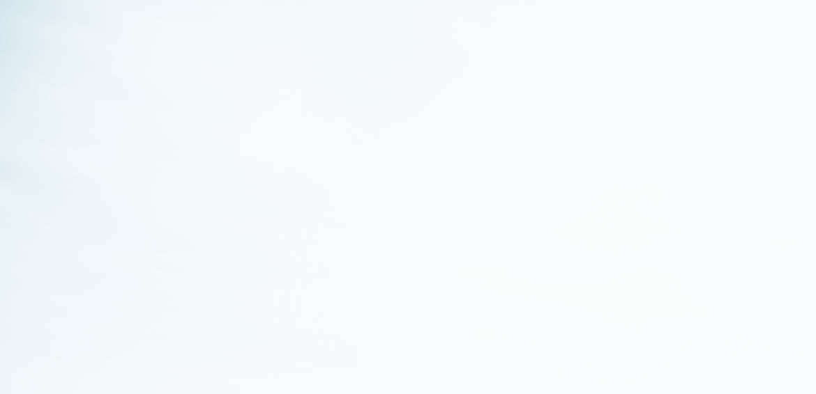 Woman standing on stone pathway in lake with arms outstretched and scarf blowing in wind