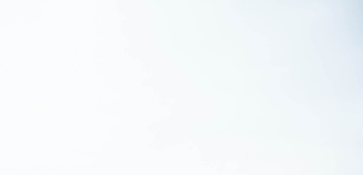 Woman standing on stone pathway in lake with arms outstretched and scarf blowing in wind