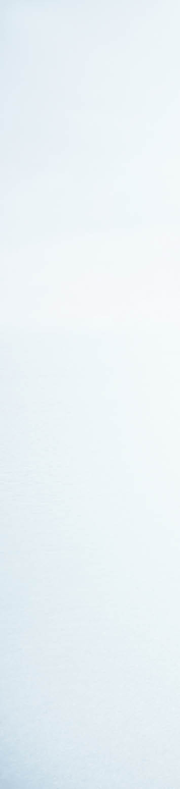 Woman standing on stone pathway in lake with arms outstretched and scarf blowing in wind
