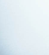 Woman standing on stone pathway in lake with arms outstretched and scarf blowing in wind