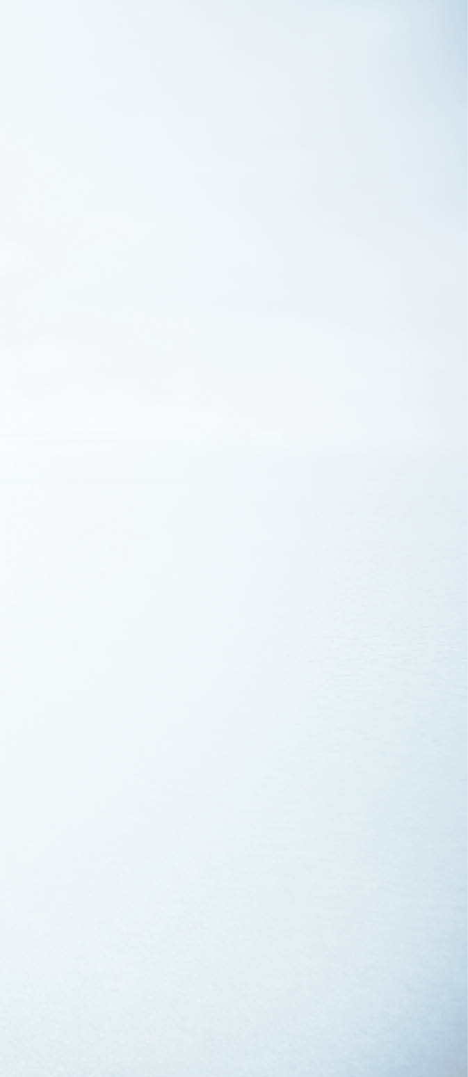 Woman standing on stone pathway in lake with arms outstretched and scarf blowing in wind